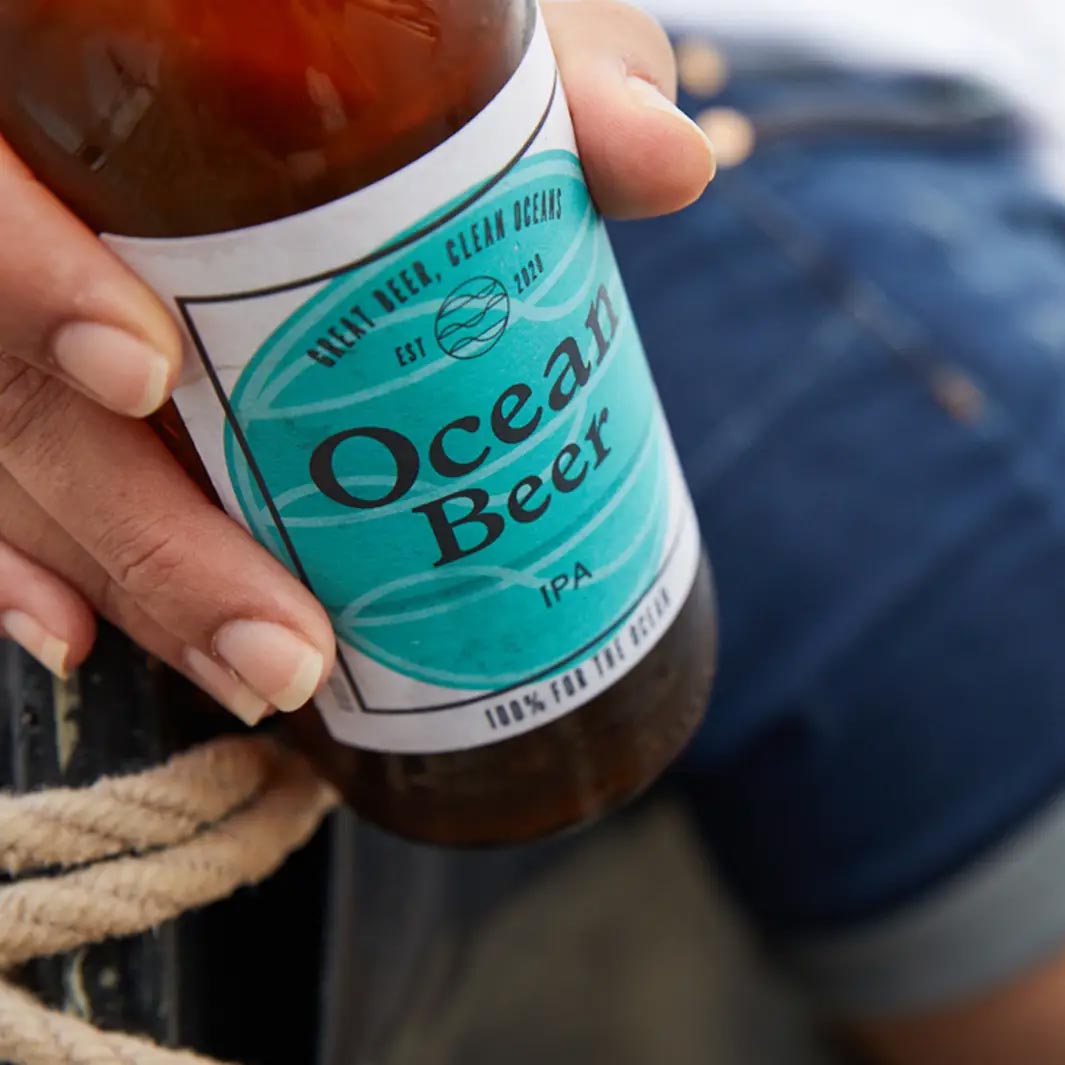 Woman drinking Ocean Beer on the beach